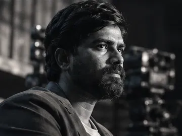 Black-and-white portrait of Thiran Chithaka on a film set.