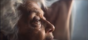 Profile of an older woman lit by a nearby window.
