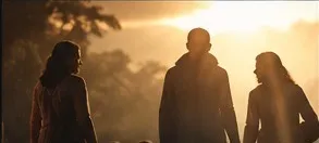 Three silhouetted figures in warm evening light.